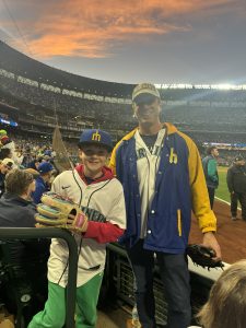 Two Mariners fans with ball gloves at T-Mobile Park at sunset during BoatLaw's ALCS Game 3 outing