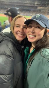 Two women smiling in the stands at BoatLaw's team outing to ALCS Game 3 at T-Mobile Park
